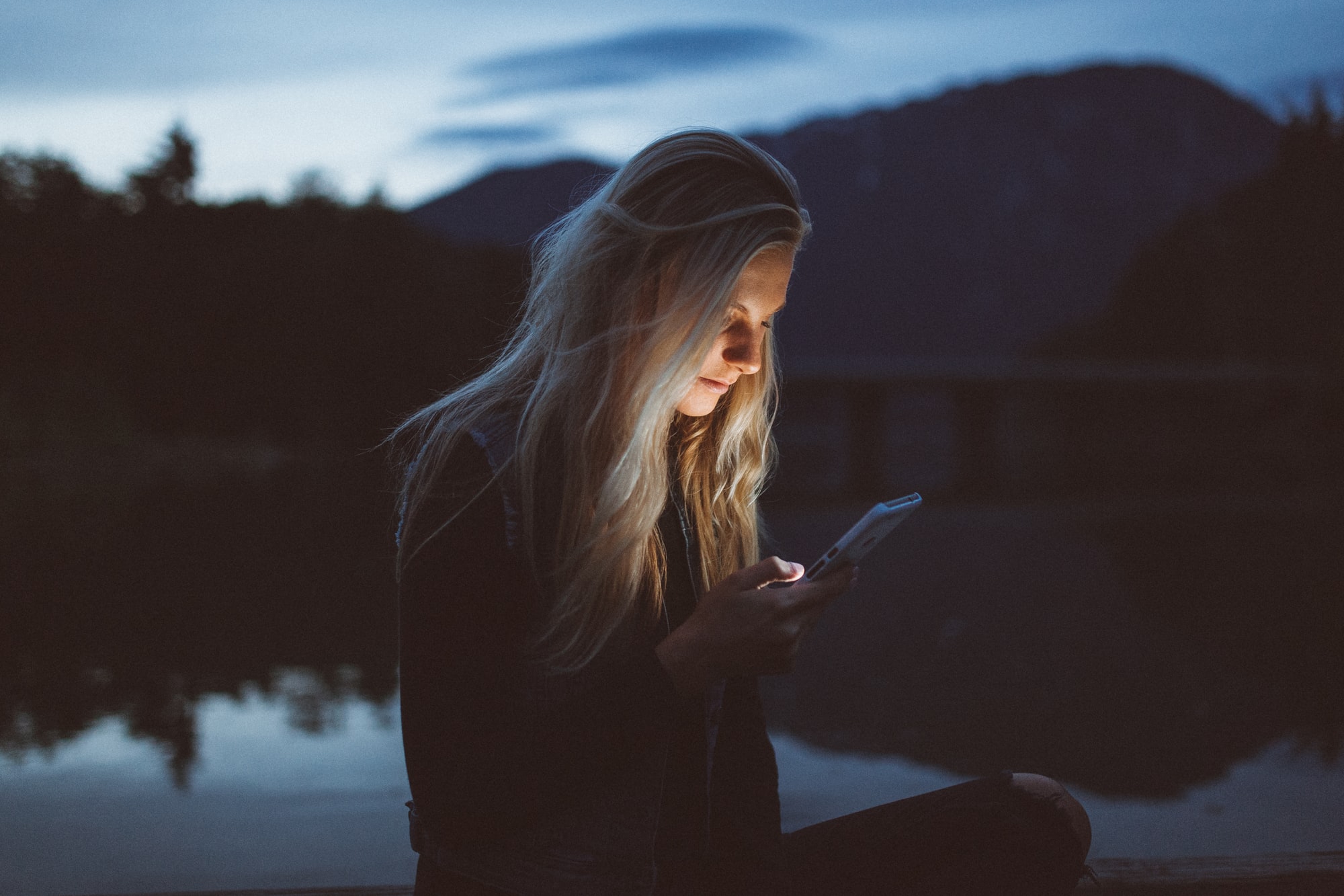 Woman with lit face from mobile phone. Credits: Becca Tarpet @ Unsplash